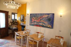 a dining room with tables and a painting on the wall at Le Stanze dei Nonni in Avellino