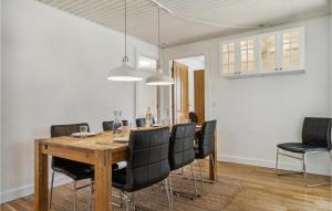 a dining room with a wooden table and black chairs at Holiday Home Rodby Ii in Kramnitse