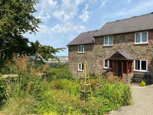 an old stone house with a garden in front of it at Heron Cottage in Shrewsbury