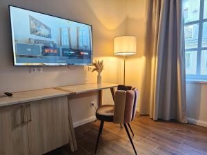 a room with a desk with a tv and a chair at Boutique Hotel Parklane - Newly Renovated in Vienna