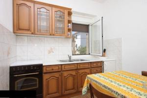 una cucina con mobili in legno e un lavello di Apartment Zvone a Veli Rat