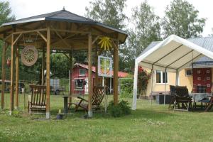 a pavilion with chairs and a table in a yard at Ferienwohnung - Gamla Huset in Gamleby +8 photos