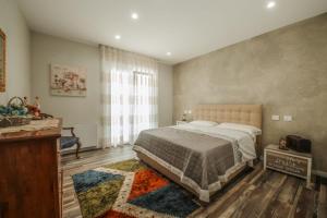 ein Schlafzimmer mit einem Bett und einem großen Fenster in der Unterkunft Enotria Villas - Villa Vittoria Luxury in Coccorino + 24 Fotos