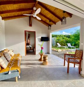 a living room with a couch and a ceiling fan at Pavillon Kanowa in Grand-Bourg