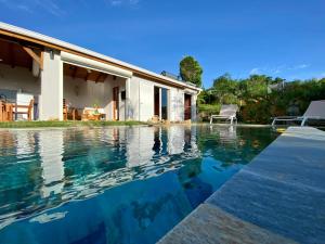 a swimming pool in front of a house at Pavillon Kanowa in Grand-Bourg