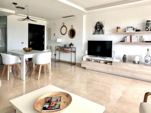 a living room with a television and a table and chairs at Appartement du Bonheur - La Cala Resort in Mijas Costa