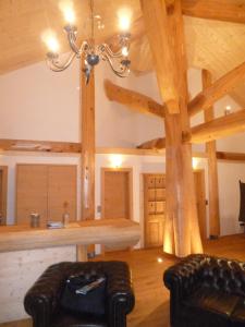 ein Wohnzimmer mit Holzbalken und einem Kronleuchter in der Unterkunft Adlernest Lechtal in Bach