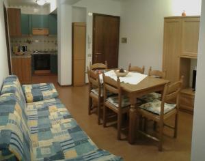 Appartamento Italia في أليغي: مطبخ وغرفة طعام مع طاولة وكراسي