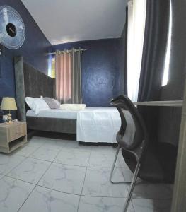 Un dormitorio con una cama y una silla dentro. en Mtwapa cosy 1 bed, en Mtwapa