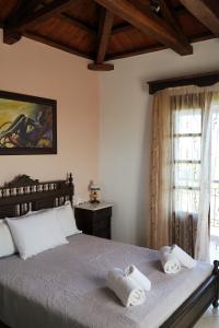 a bedroom with a bed with two towels on it at Vatellis Villas in Patitiri