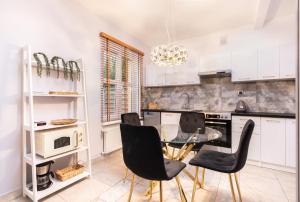 a kitchen with black chairs and a glass table at Domek blisko plazy in Świnoujście