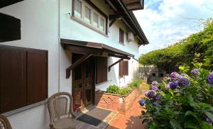a white house with a door and some flowers at Musicians Mansion Apartment in Fino Mornasco