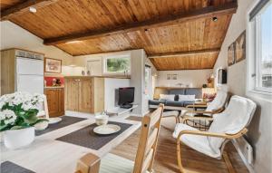 salon z drewnianym sufitem, stołem i krzesłami w obiekcie Holiday Home Østre Klitvej Fanø Xii w mieście Fanø