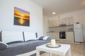 una sala de estar con un sofá y una mesa en Apartments Karma, en Novalja