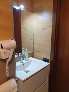a bathroom with a white sink and a mirror at Alpin House Tonale in Passo del Tonale +22 photos