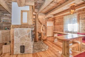 una sala da pranzo con camino in pietra in una baita di tronchi di Lodge Nadgora a Žabljak