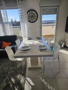 a dining table and chairs in a living room at appartement in Dijon +25 photos