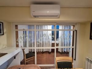 a room with a large glass door with a balcony at Apartamento Urquiza in San Carlos de Bariloche +23 photos