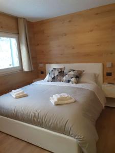 a bedroom with a bed with two towels on it at Alpin House Tonale in Passo del Tonale