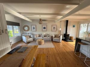 una sala de estar con un sofá y una mesa en Shoaly House and Shoaly House Cottage - perfect for multiple families & wedding groups, en Shoal Bay