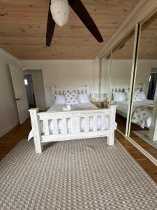 Un dormitorio con una gran cama blanca y espejos en Shoaly House and Shoaly House Cottage - perfect for multiple families & wedding groups, en Shoal Bay