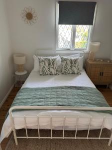 1 cama con marco blanco y ventana en Shoaly House and Shoaly House Cottage - perfect for multiple families & wedding groups, en Shoal Bay 48 fotos más