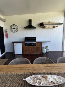 Una cocina con encimera y mesa con sillas. en Shoaly House and Shoaly House Cottage - perfect for multiple families & wedding groups, en Shoal Bay
