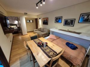 a room with a table and a bed and a living room at Apartamento Urquiza in San Carlos de Bariloche