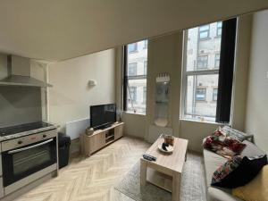 a living room with a couch and a tv at Stylish Mezzanine Apartment In Central Leeds in Central Station