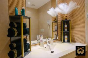 a bathroom with a sink and some bottles of wine at FLH - 777 Apartments in Bucharest