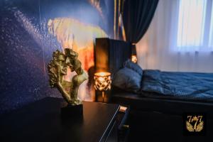 a statue on a table in a room with a bed at FLH - 777 Apartments in Bucharest +20 photos