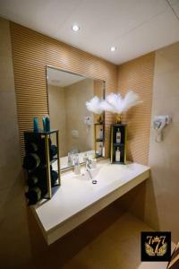 a bathroom with a sink and a large mirror at FLH - 777 Apartments in Bucharest