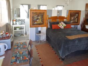 a bedroom with a bed and a table at Karoo Pomp in Vosburg