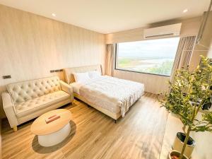 Fair Tale Motel - Sea في مدينة هوالين: غرفة نوم بها سرير وأريكة وطاولة