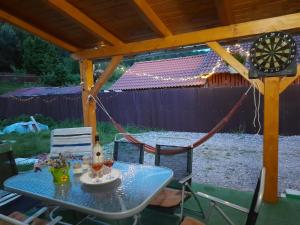 una mesa y sillas bajo un cenador en Mountain Cozy Home, en Sub Cetate