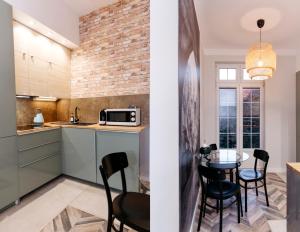 a kitchen and dining room with a table and chairs at Neptunus MB By the Ses Apartments OLD TOWN in Gdańsk