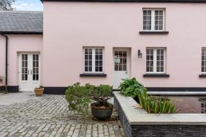 a white and pink house with a courtyard at The Coachhouse, East Budleigh , Sleeps 4 in East Budleigh