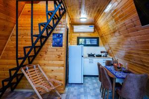 a kitchen and dining room with a staircase in a tiny house at Kvabtkari Cottages in Ambrolauri