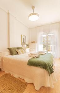 a white bedroom with a large bed and a window at El Paraiso - Planta baja en Urbanización Ipanema III La Manga del Mar Menor kilómetro2 - Mediterráneo in La Manga del Mar Menor