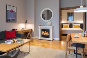 een woonkamer met een open haard en een slaapkamer bij STRADONIA Serviced Apartments in Krakau