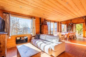 un soggiorno con un divano e un tavolo di CHALET SPA BELLE VUE 500 m des pistes a Manigod