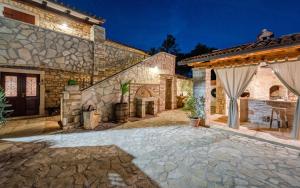 an exterior view of a stone house with a patio at Rustic stone holiday house with pool in Marčana