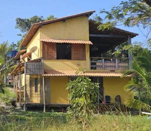 a yellow house in the middle of a field at Casa no Mangue in Marau