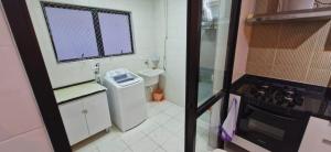 a small bathroom with a sink and a stove at Apartamento Praia das Pitangueiras - Condomínio Golden Tower in Guarujá +25 photos