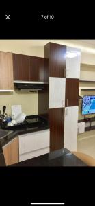 a kitchen with wooden cabinets and a phone on a counter at Modern & Cozy Homey Condo in Avida Riala Towers Cebu City IT Park T1 in Cebu City +3 photos