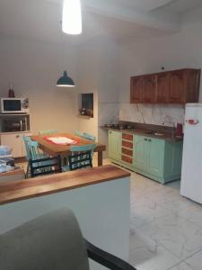 una cucina con tavolo, sedie e frigorifero di Sobrado Novo 3 quartos a São Lourenço do Sul