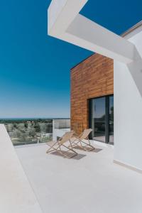 Deux chaises sur le toit d'une maison dans l'établissement Villa Aria Višnjan near Poreč for 12 people - pet friendly with wellness & sea view, à Višnjan