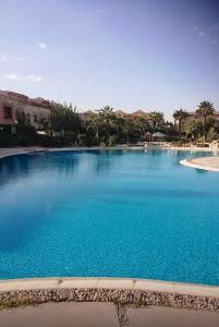 a large swimming pool with blue water at room inside villa in Cairo
