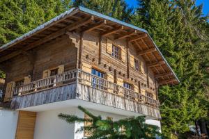 una casa con un balcone in cima di CHALET SPA BELLE VUE 500 m des pistes a Manigod