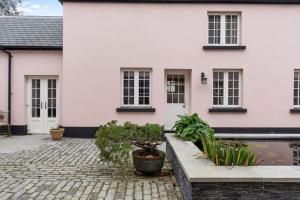 une maison blanche avec des plantes devant dans l'établissement Coachmans Cottage, East Budleigh, Sleeps 6, à East Budleigh